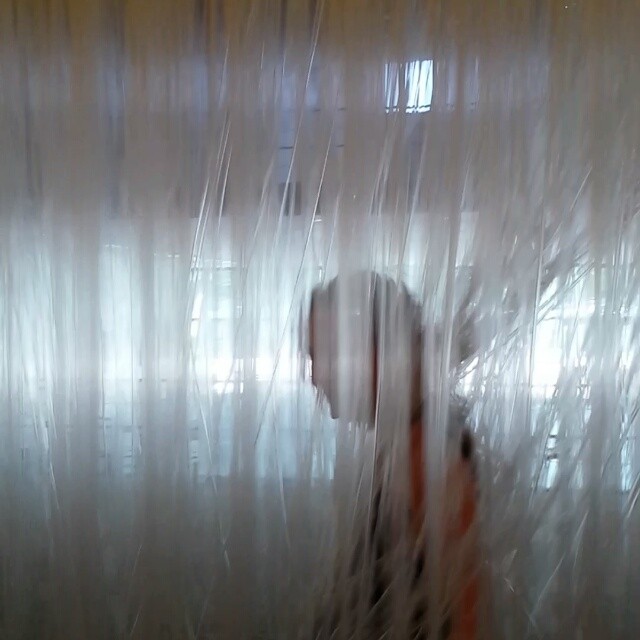 blurry pograph of someone peeking through white curtains