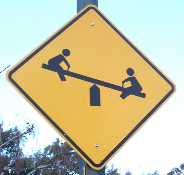 a yellow crossing sign sitting on the side of a pole
