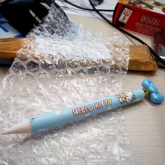 a pen and a tube of tooth paste sitting in plastic wrap