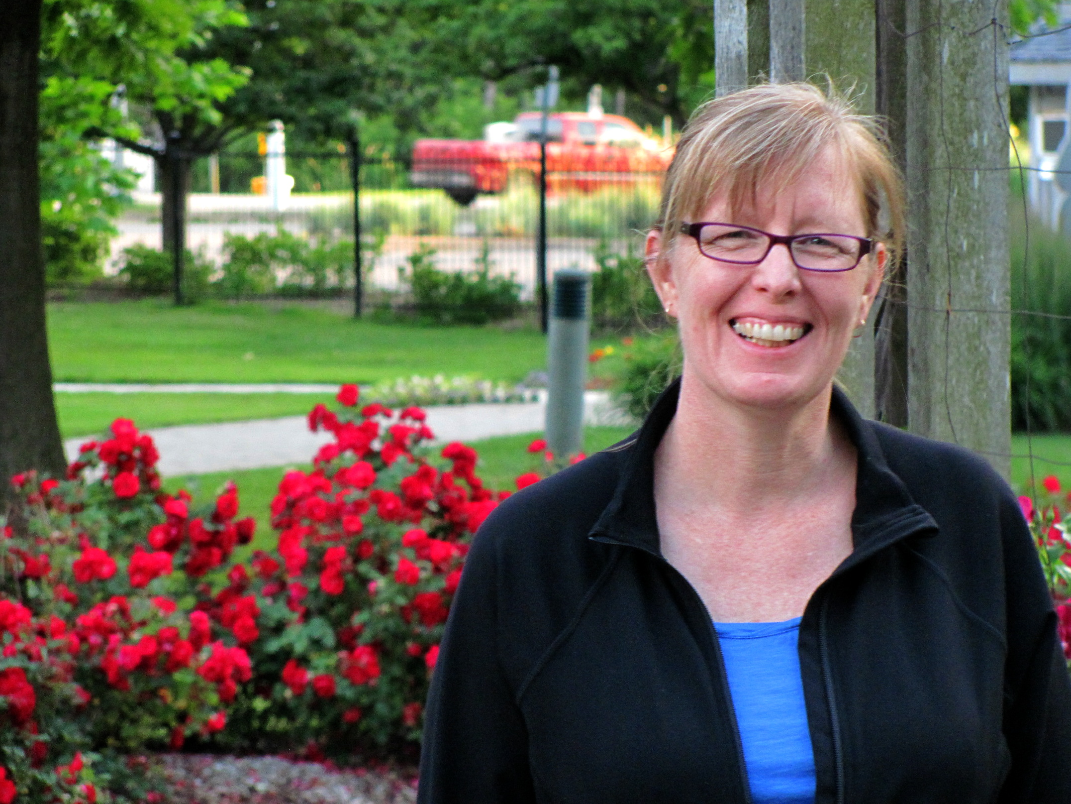 a woman smiling for the camera and flowers around her