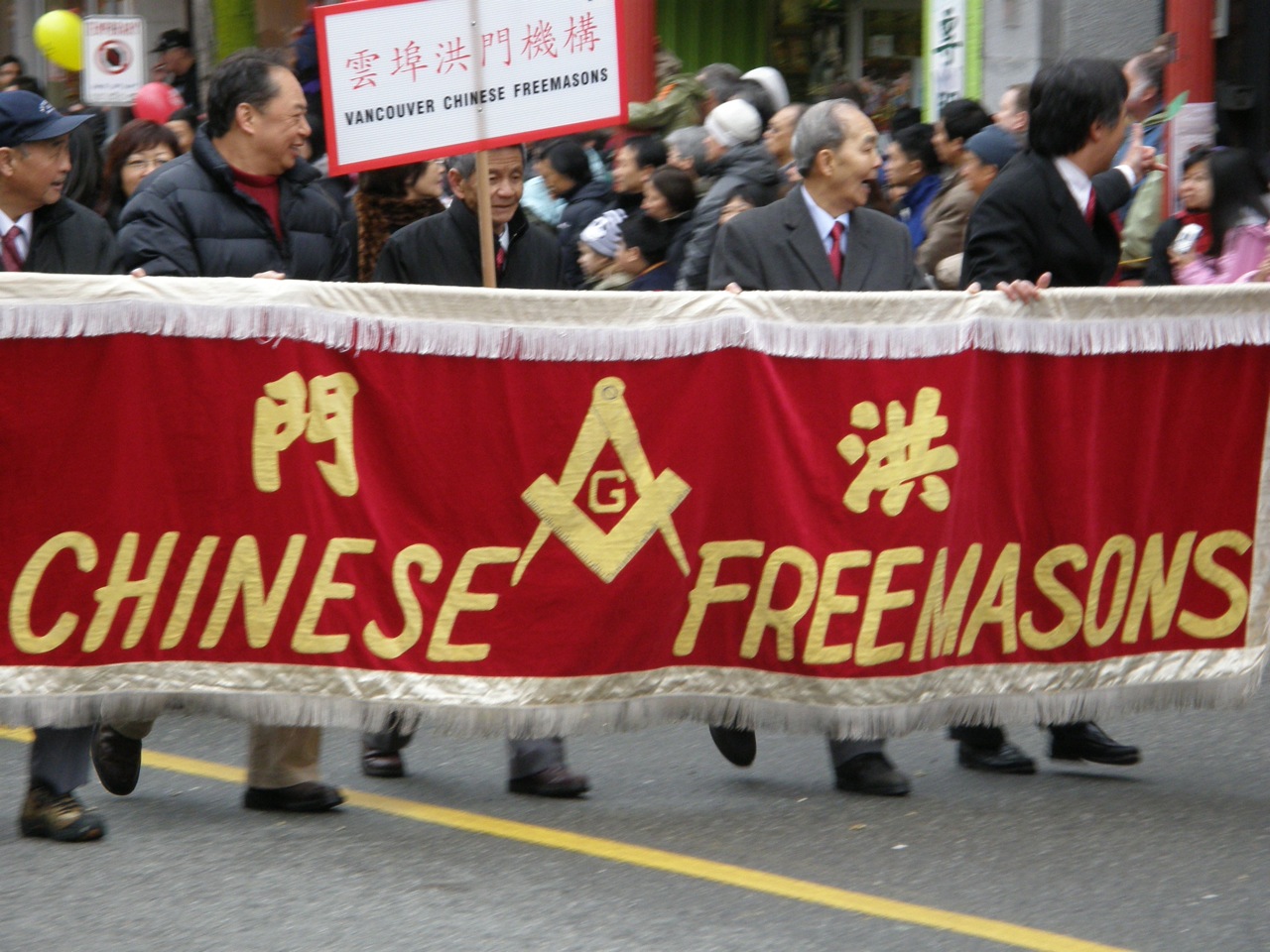 a group of people walking down a street carrying a banner