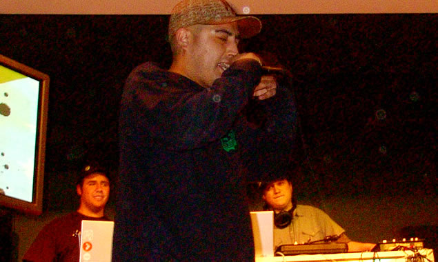 a man standing in front of microphone with other men