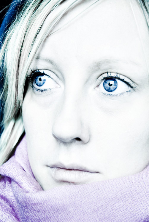 a woman wearing a scarf with blue eyes staring in the camera