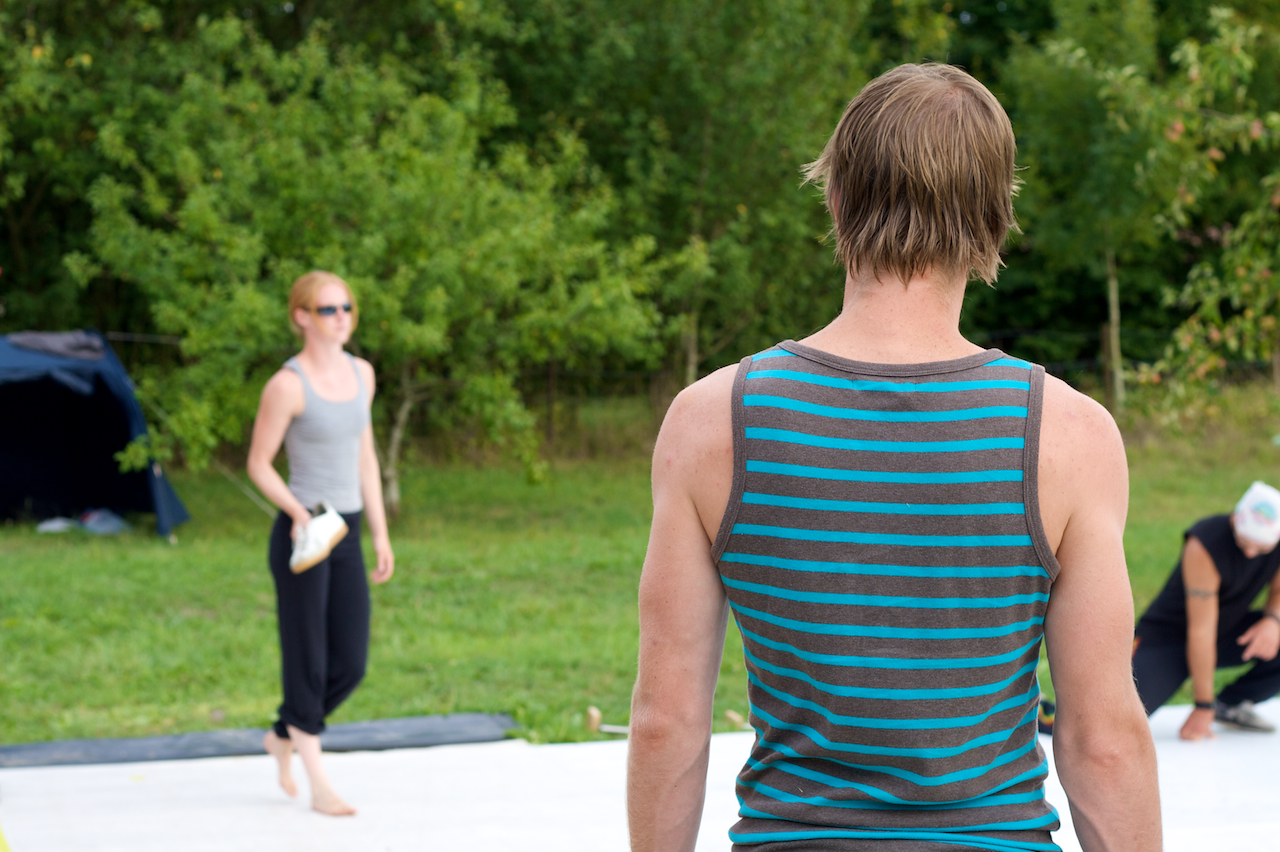 a woman and man in a park during a yoga session