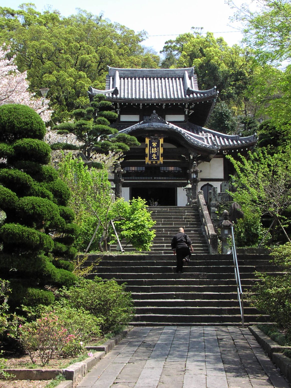 the steps to a pagoda are lined with trees and shrubs