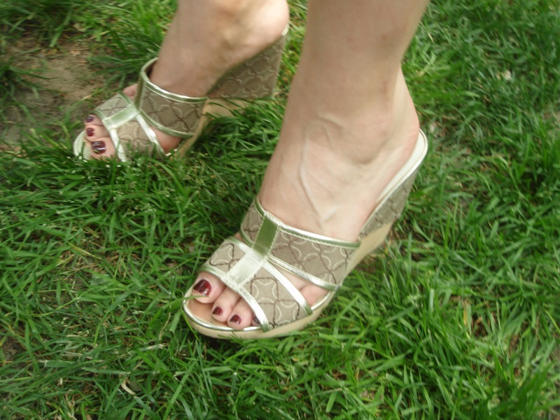 woman with metallic metallic shoes stands on grass