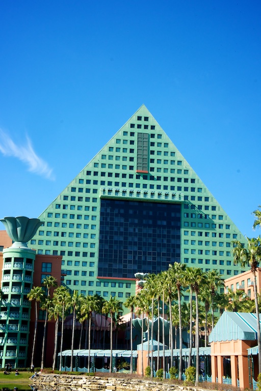 a pyramid building with palm trees and tall buildings