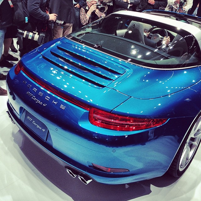 a blue porsche convertible parked on top of a white table