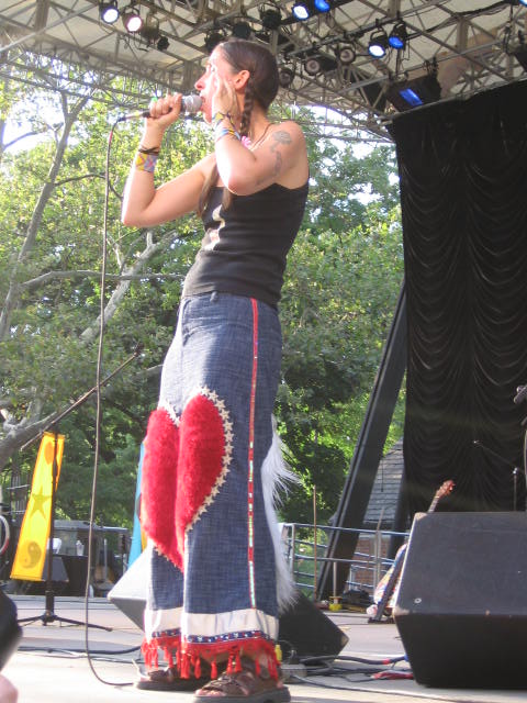 a woman in a skirt standing on stage singing