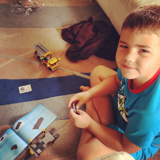 a boy plays with some construction toys on the floor