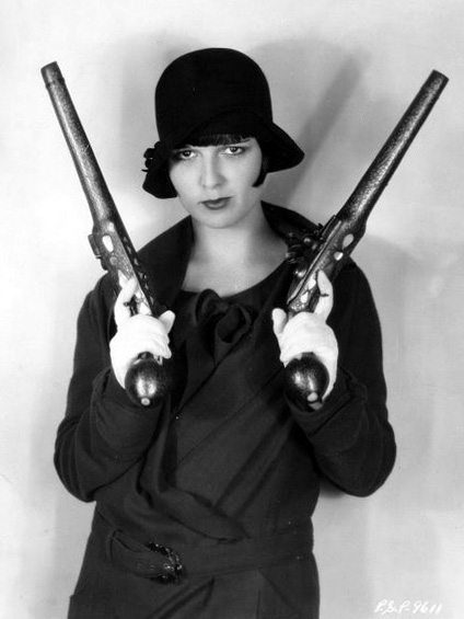 a black and white po of a woman holding two guns