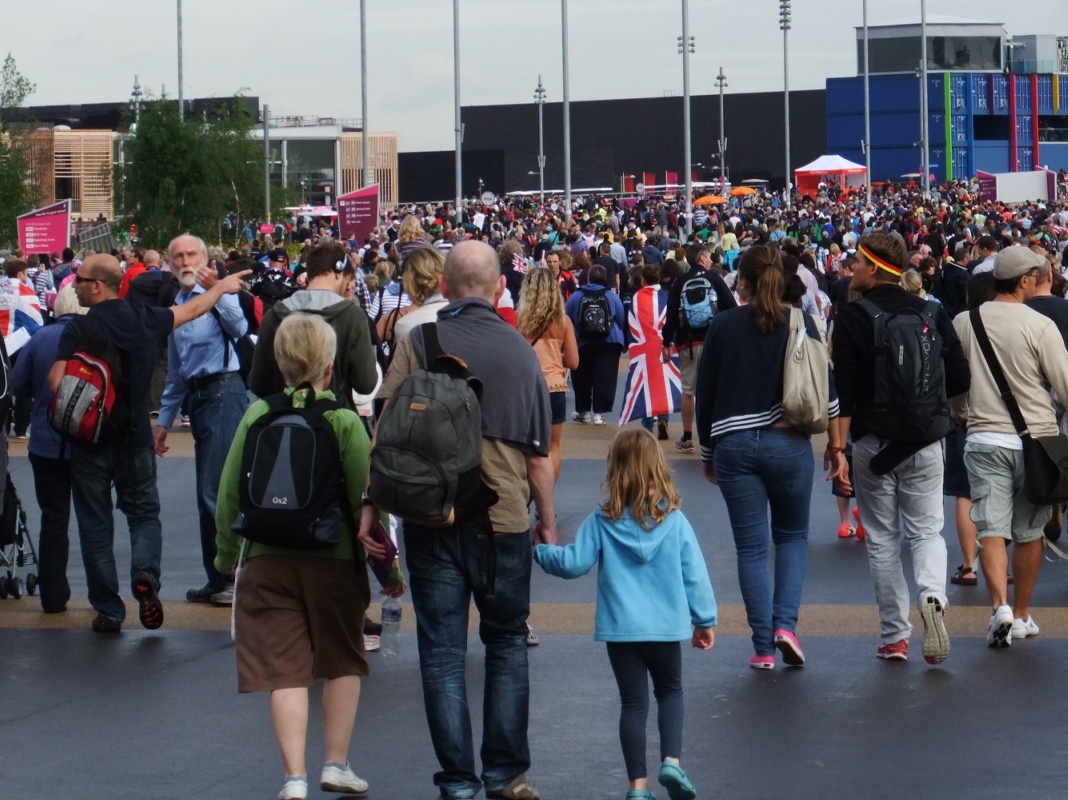 many people walking in front of a stadium