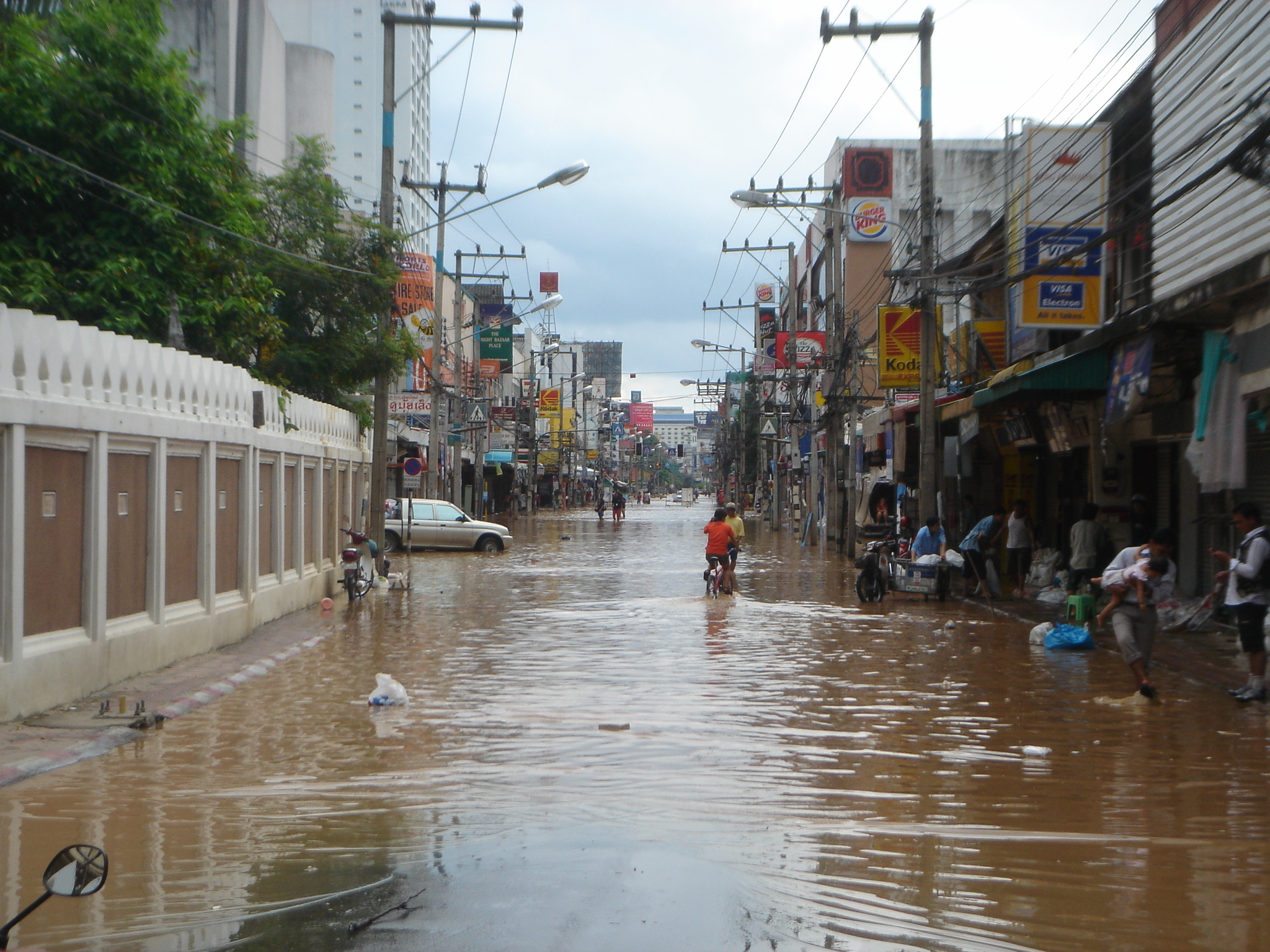 an image of people walking through a flooded street