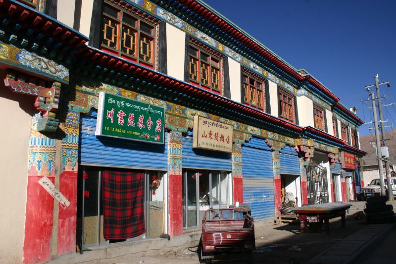 an old asian building with large wooden windows and lots of signs