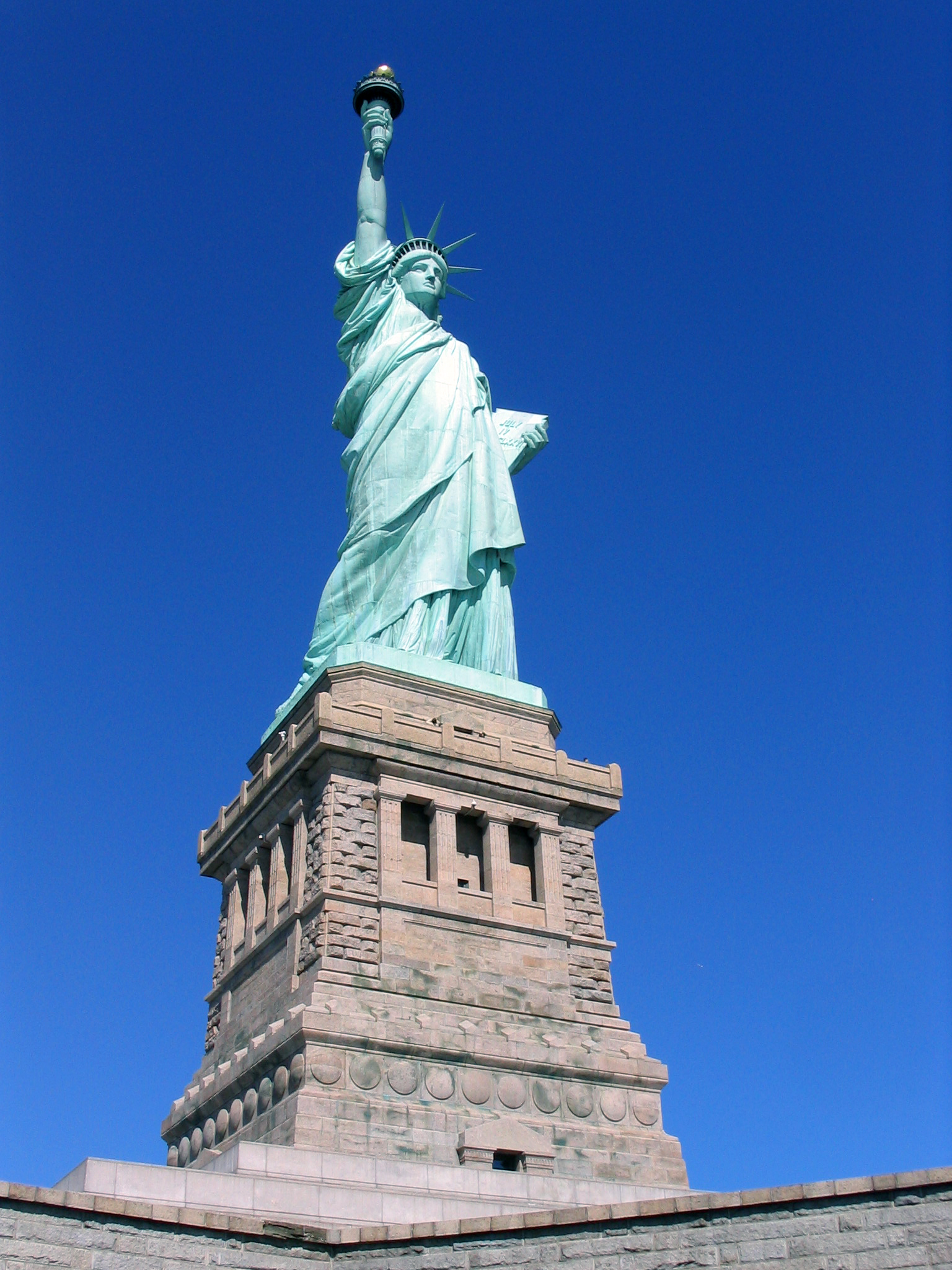 the statue of liberty sits in front of a brick building