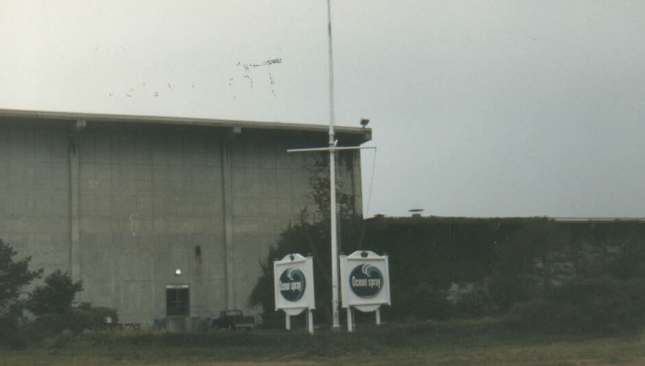 two sign poles with a flag on top are in front of a building