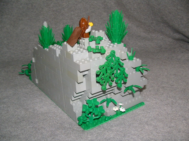 a lego castle with a toy horse and some grass