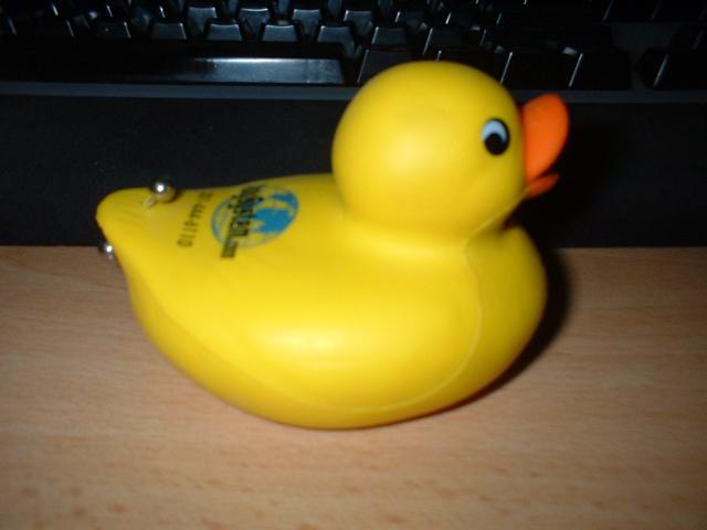 the rubber toy rubber duck is in front of the keyboard