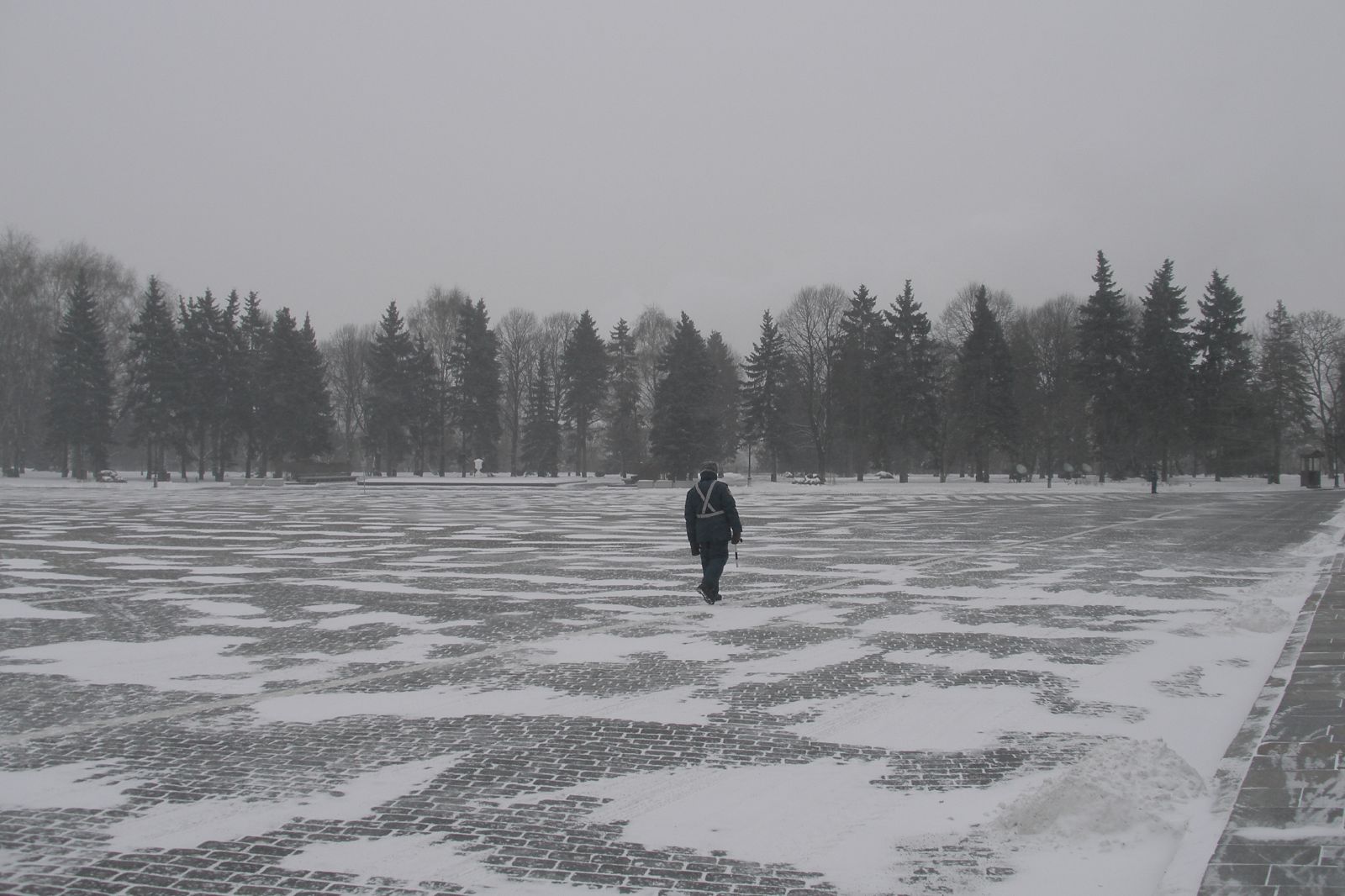 a lone person walking through the snow covered field