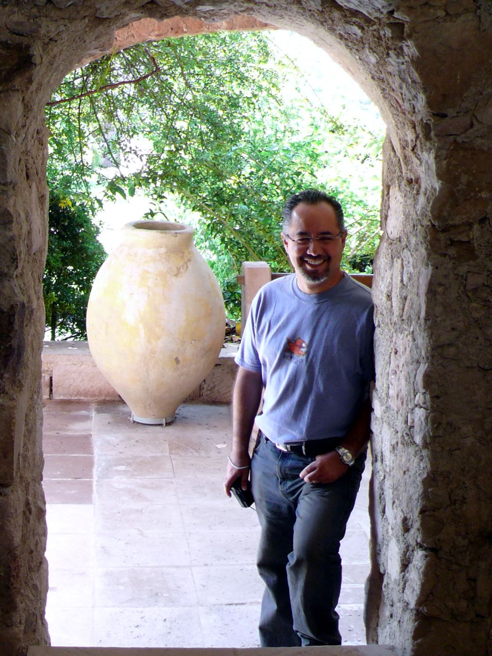 a man standing next to a white vase on a patio