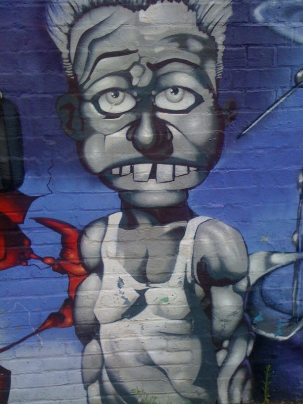 a man with gray hair and eyes wearing glasses is painted on the side of a wall