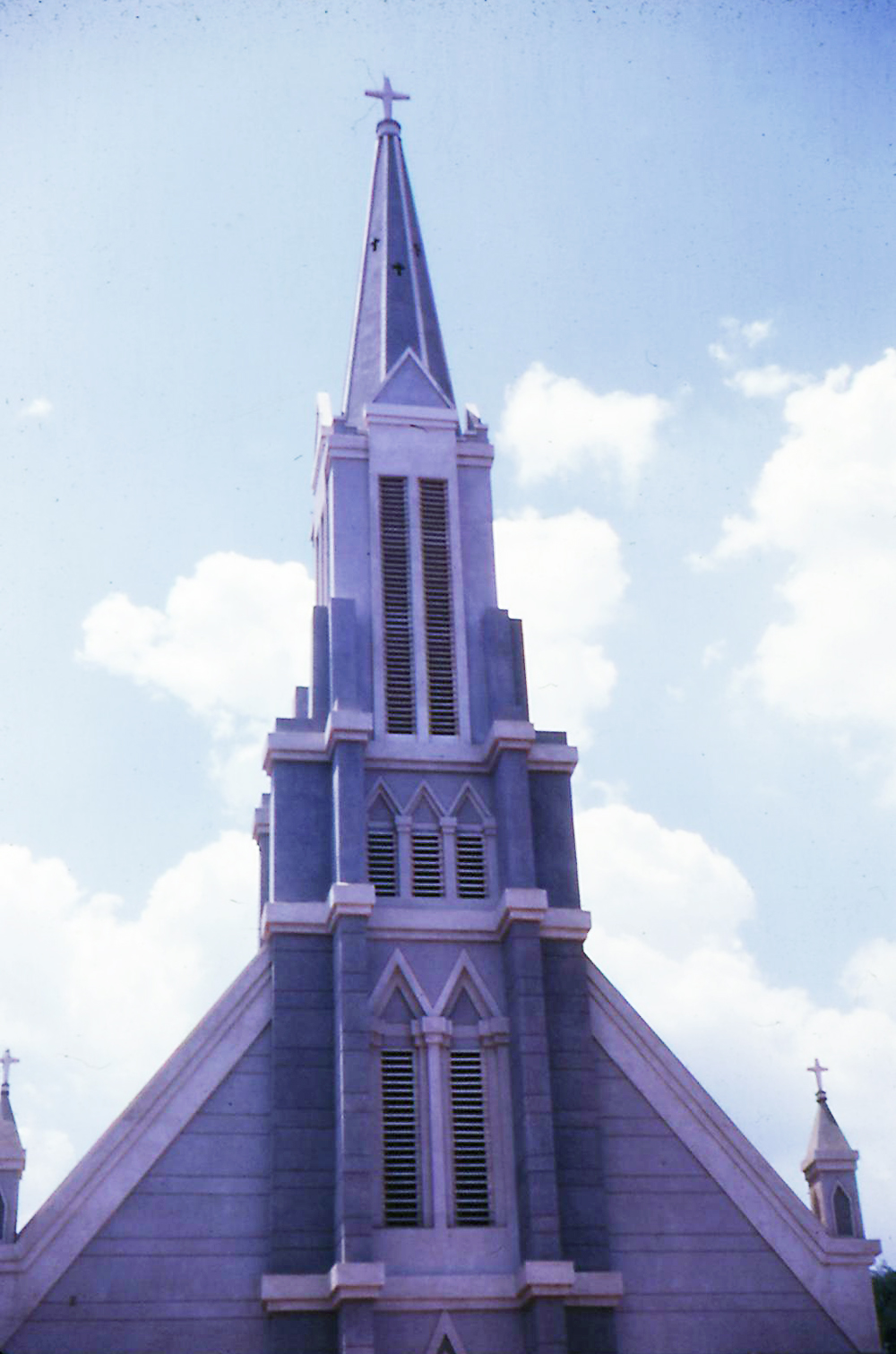 a cathedral like structure has a steeple with a cross at the top