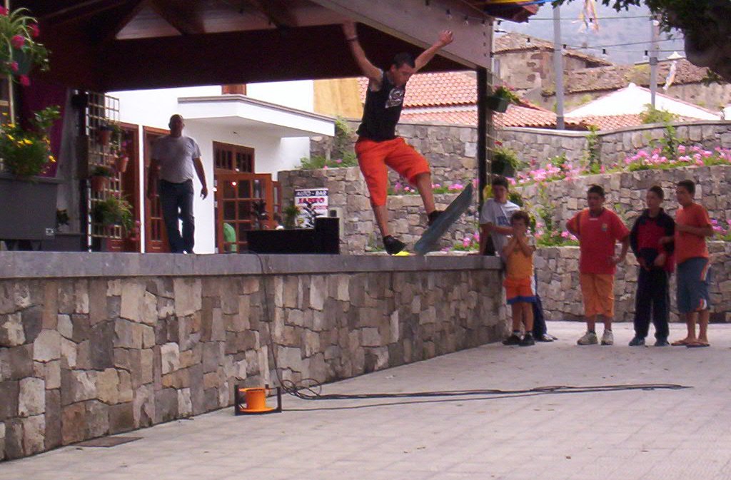 a man doing tricks on his skateboard while people watch