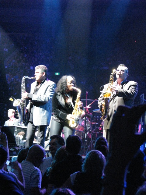 people in an arena playing music with lights coming from the ceiling