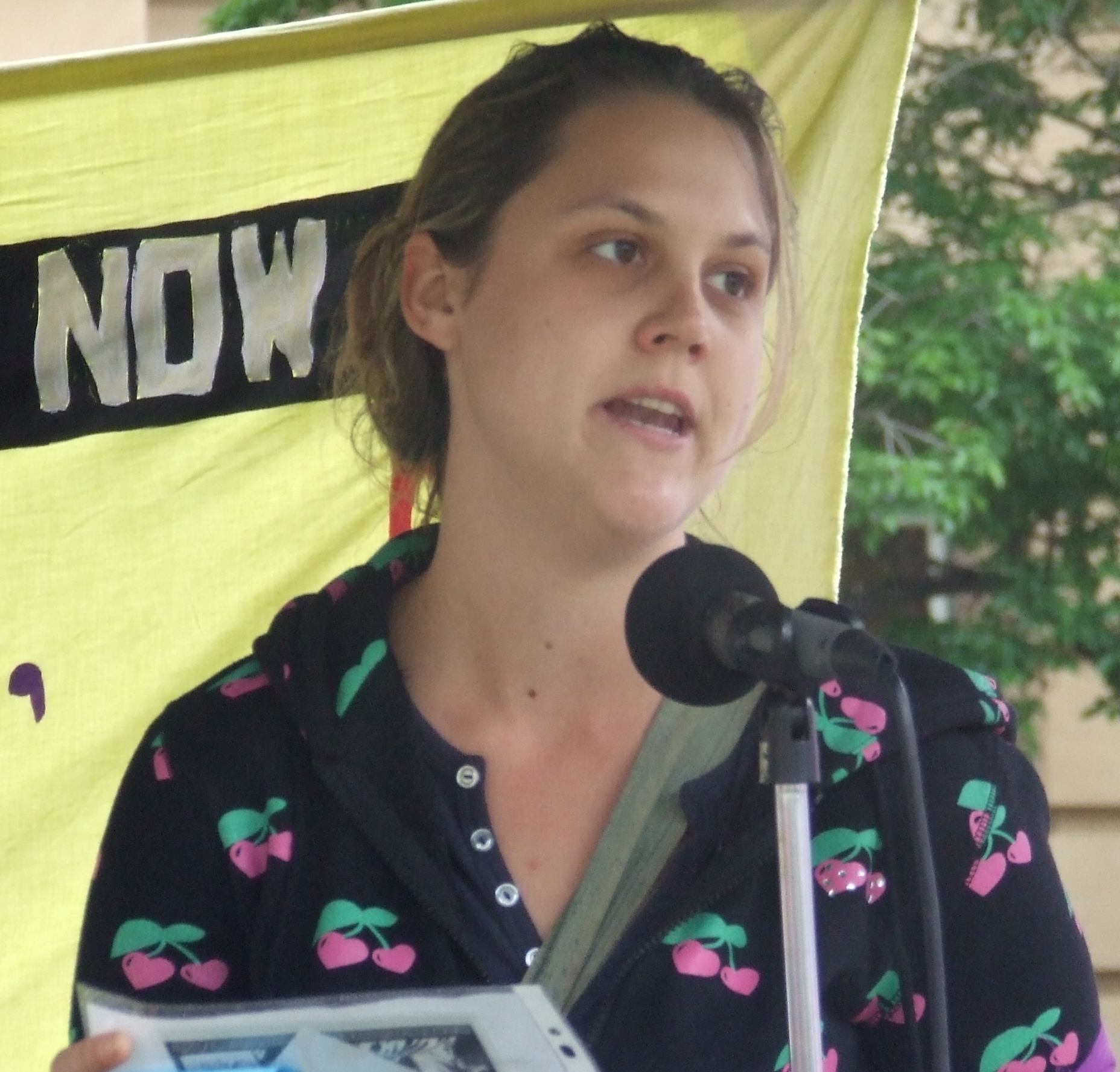 there is a woman holding a tablet computer next to a microphone