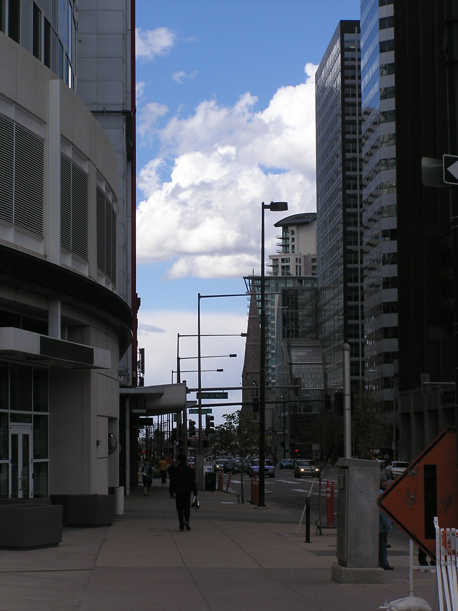 a man walking down a sidewalk in between some buildings