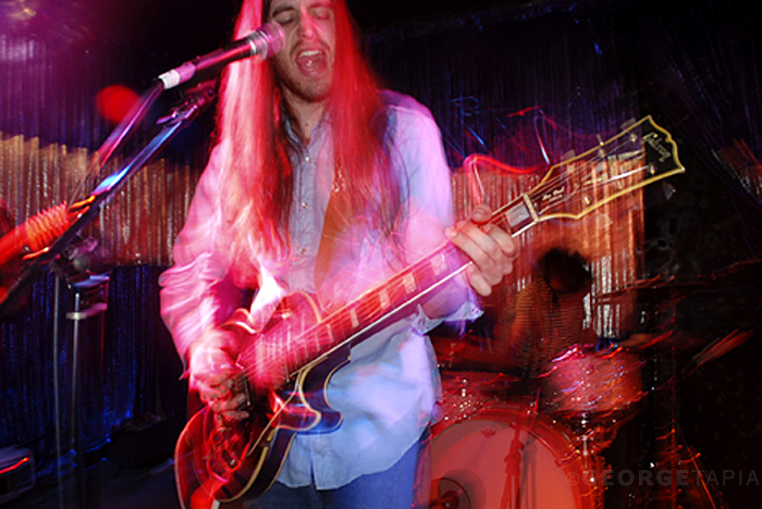 the musician has long red hair and is playing guitar