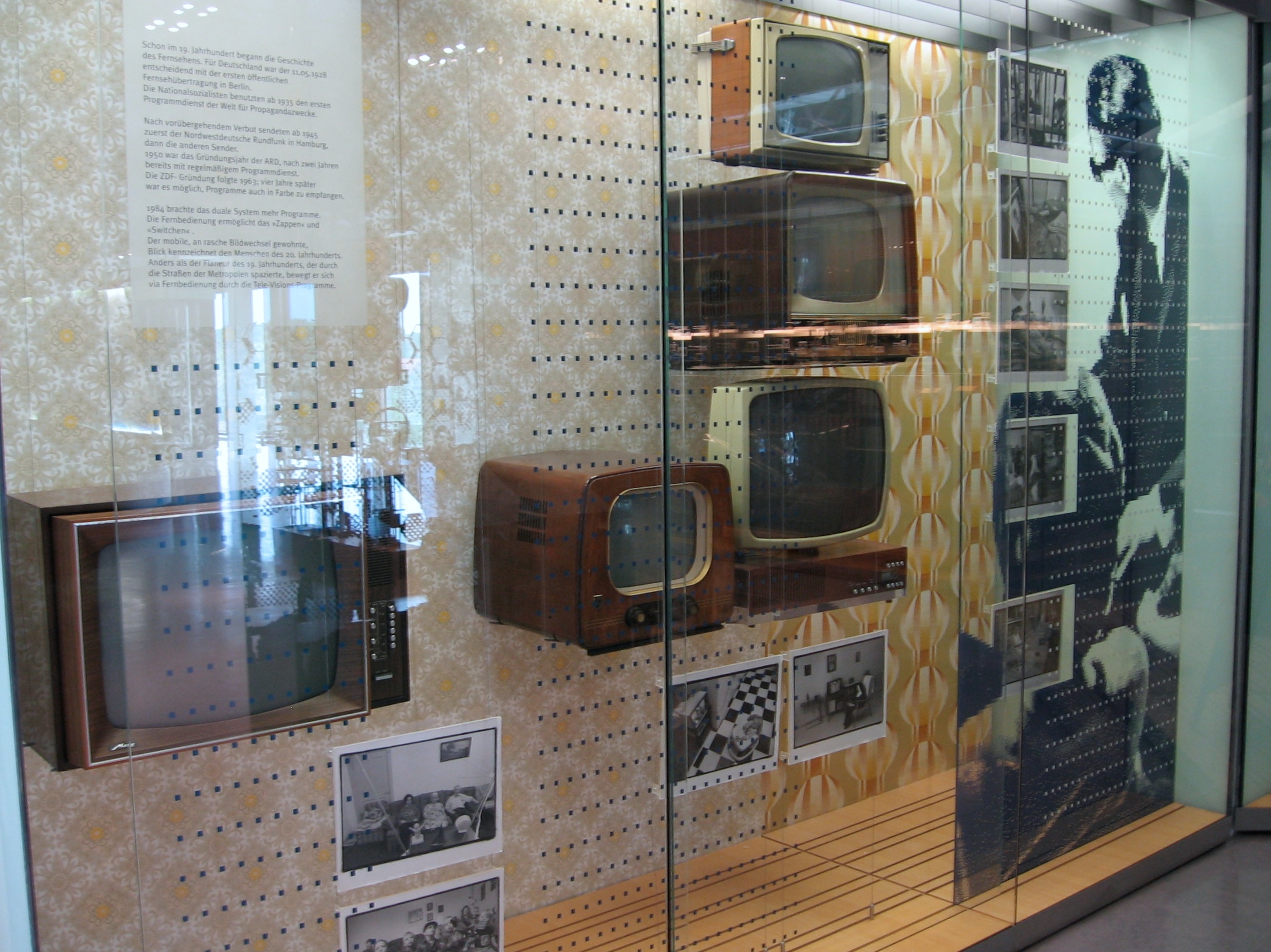 a display case filled with old televisions on top of glass