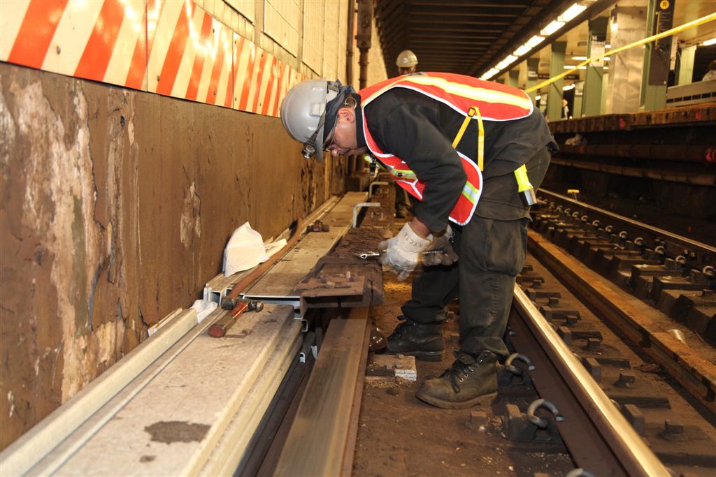 a man in safety gear working on metal rails