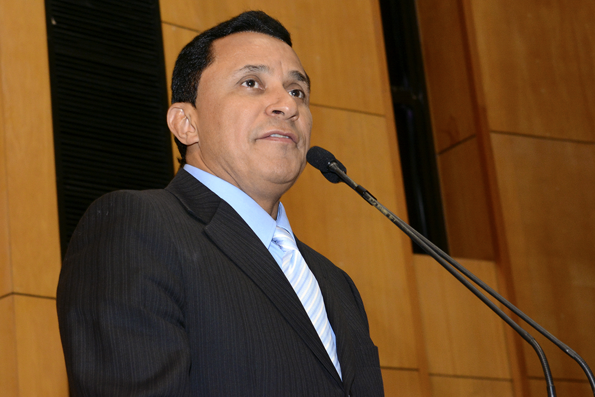 a man wearing a suit and tie is talking into a microphone