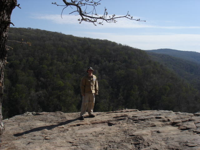 the man stands on top of a large rock formation