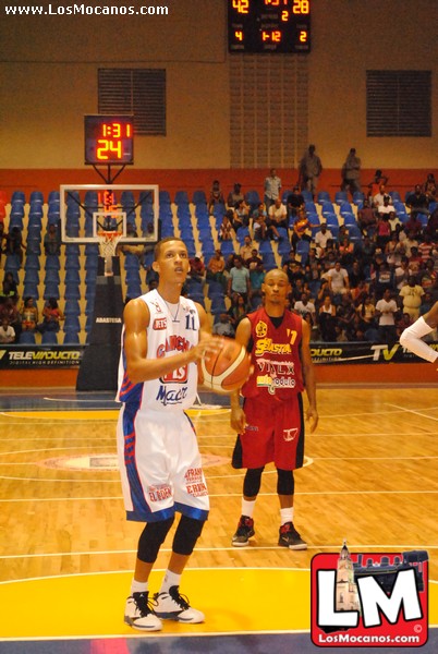 a male basketball player wearing a blue and white uniform with an arm around a man