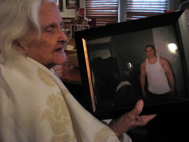 a woman holds up an old po with her man in the background