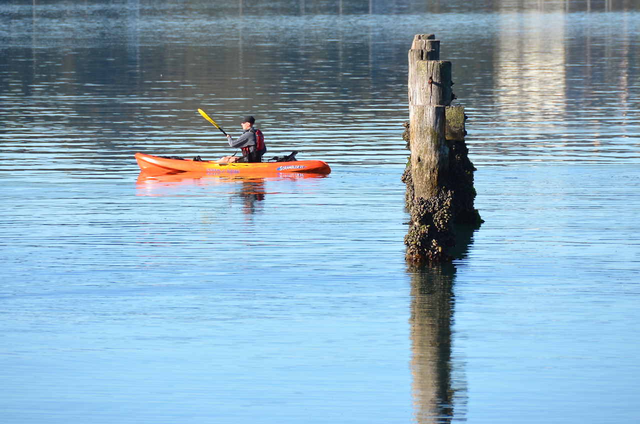 a man is riding in a kayak down the lake