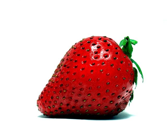 a fresh strawberry with brown dots on the side