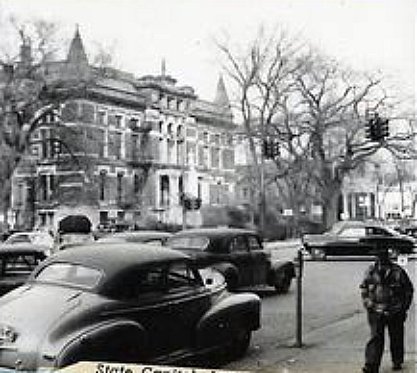 an old black and white po of police and cars in a city