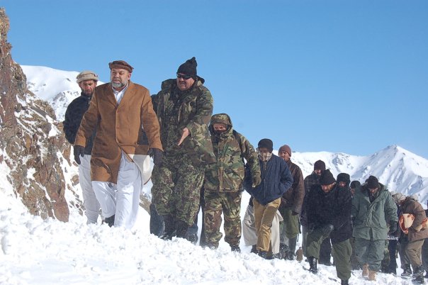 a bunch of people walk up a snow covered hill