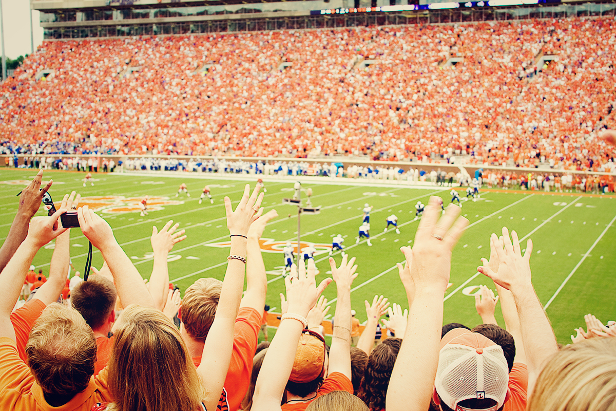 many students watching a football game in an arena