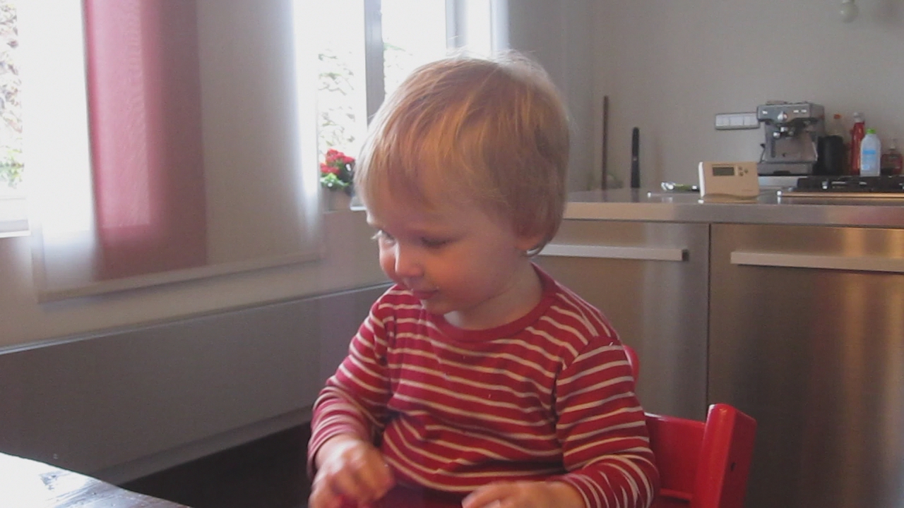 a young child sitting in a chair eating some food