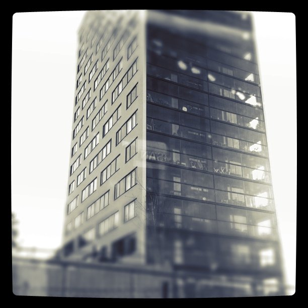 black and white pograph of tall building near sidewalk