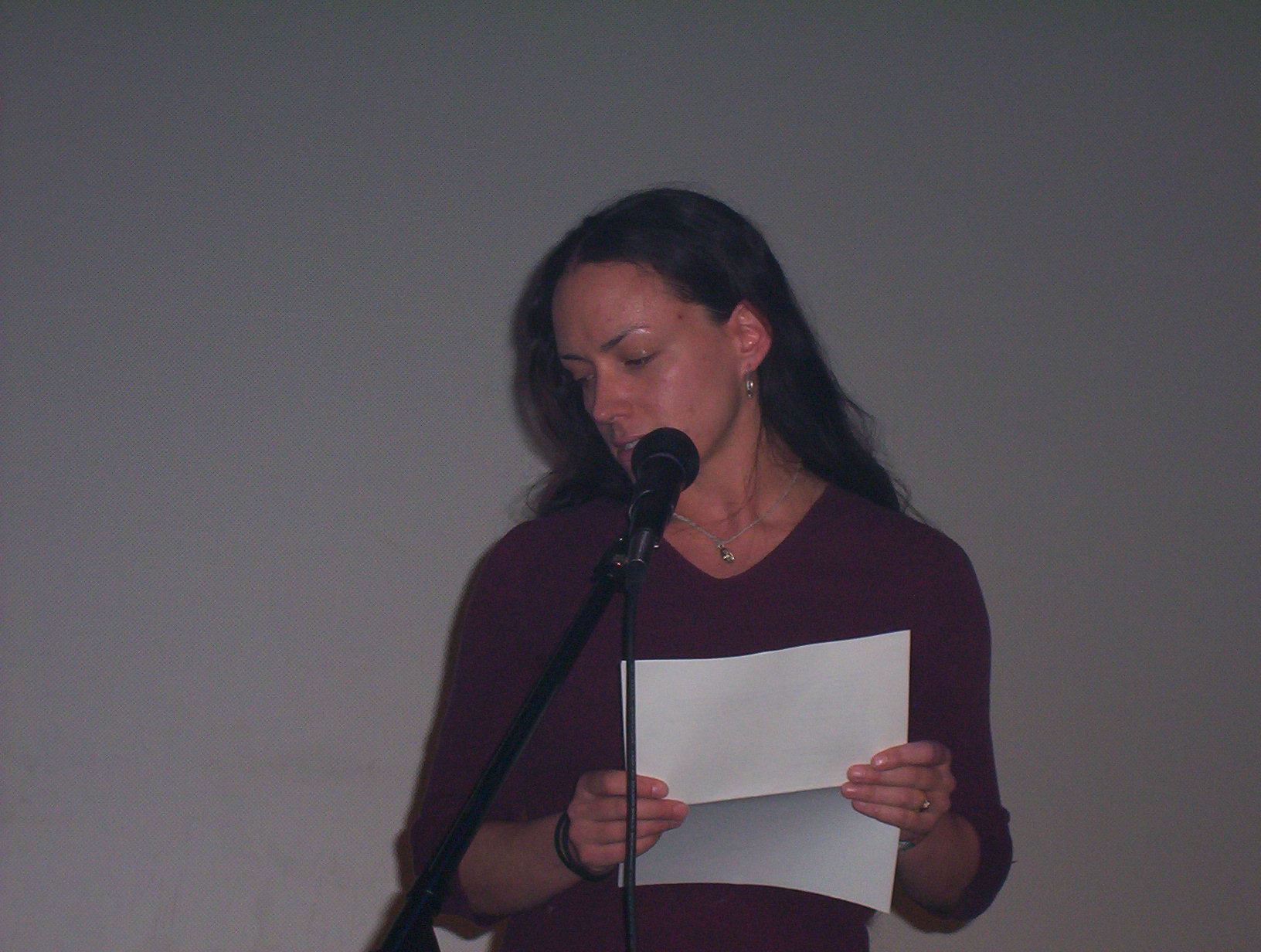 a woman in a purple shirt reading a speech