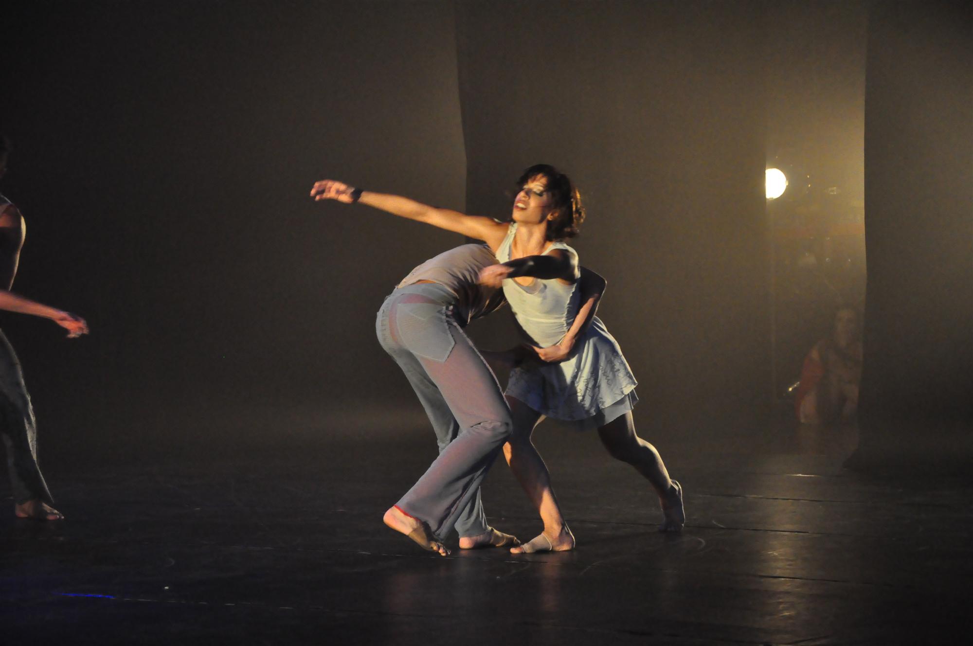 two dancers pose while another dances behind them