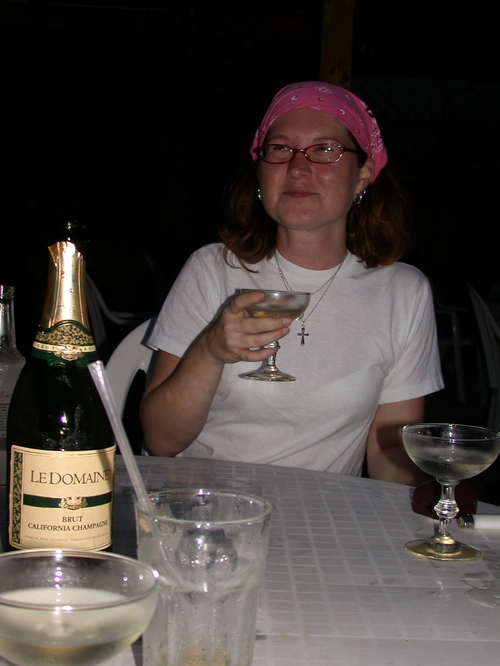a woman drinking wine at a table with two glasses