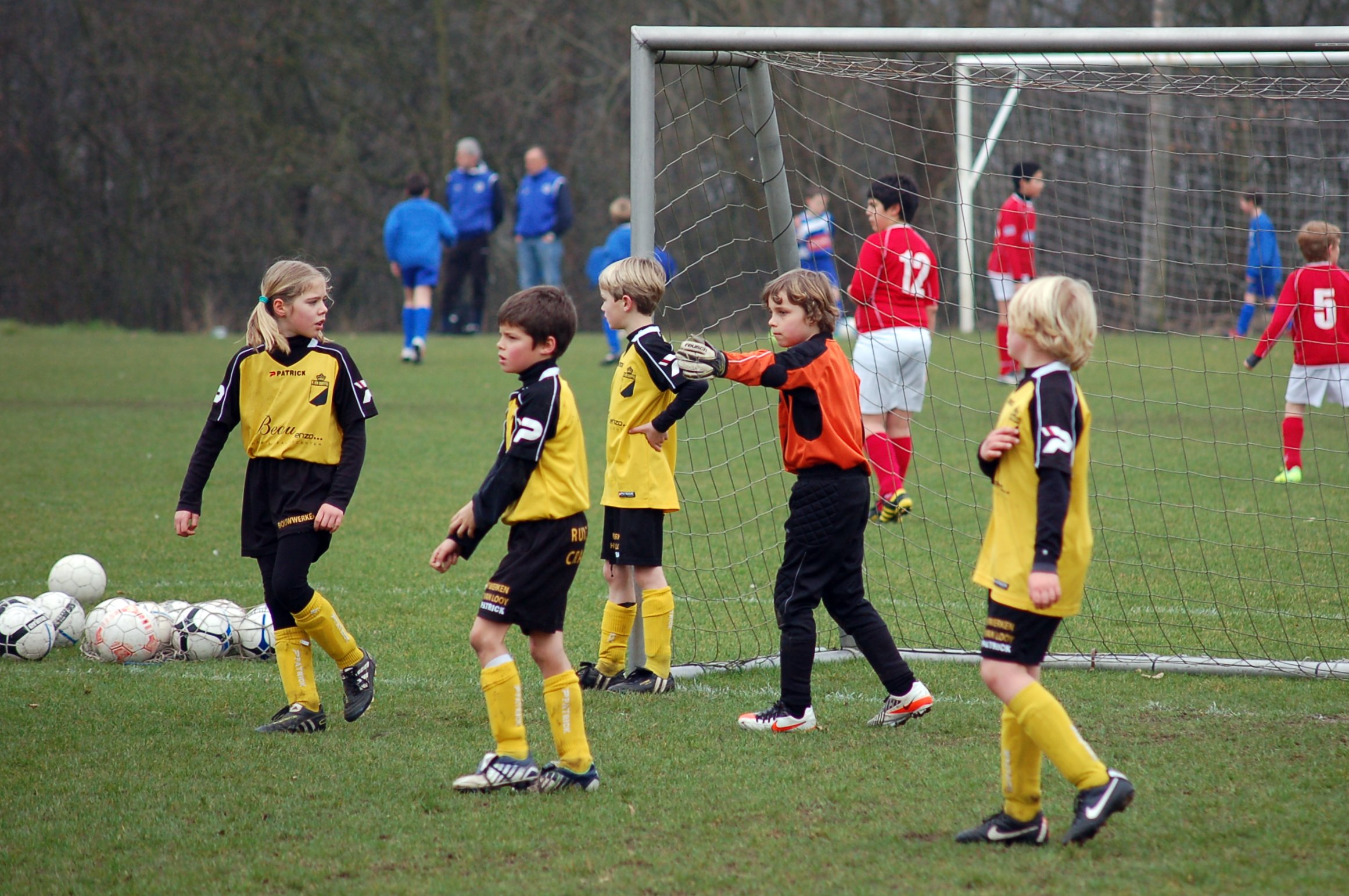 a group of s and girls standing next to a soccer ball