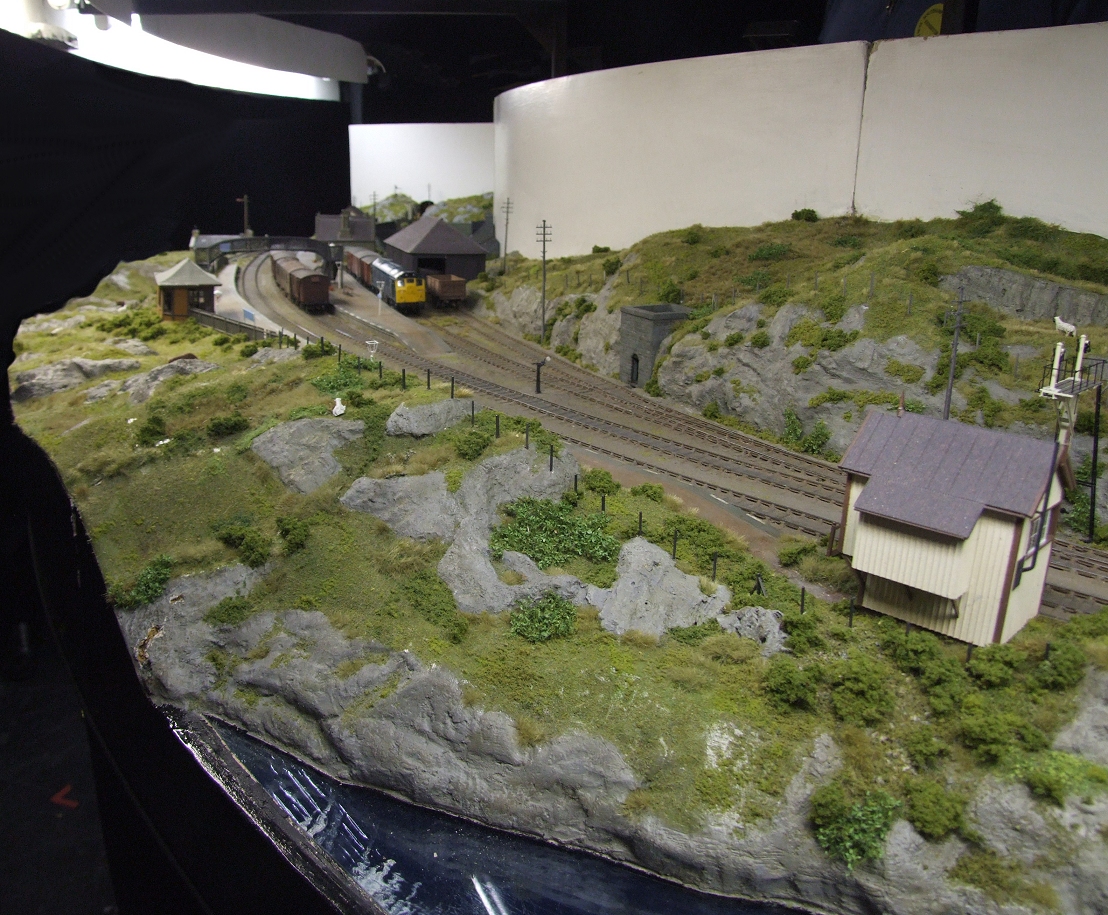 an overhead view of a model train station and mountain landscape
