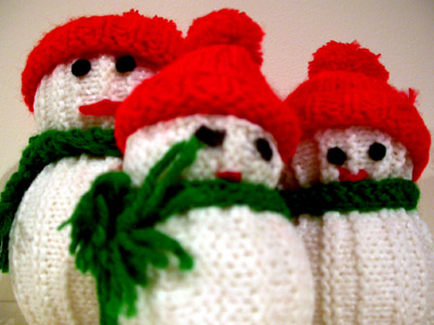 knitted ornaments that are red and green on top of a white table